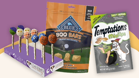 Shows a selection of Halloween-themed pet treats, including Temptations "Tasty Human" treats, Blue boo-treats, and Claudia's halloween treat pops.