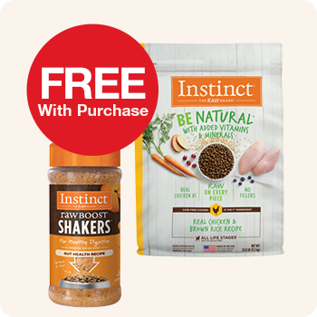 A bag of Instinct Be Natural dry dog food next to a bottle of Instinct Raw Boost Shakers, with a red circular label that says "FREE With Purchase".
